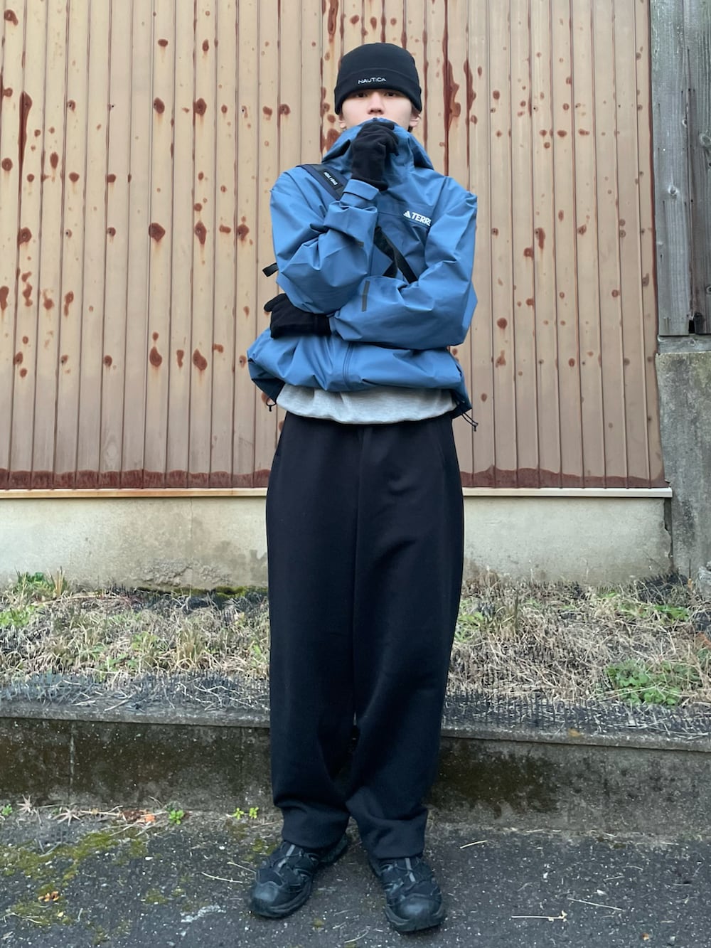 ブラック系のスニーカー、ブルー系のショルダーバッグ、ブラック系のスウェットパンツを着用したメンズの冬コーディネートの4枚目の写真