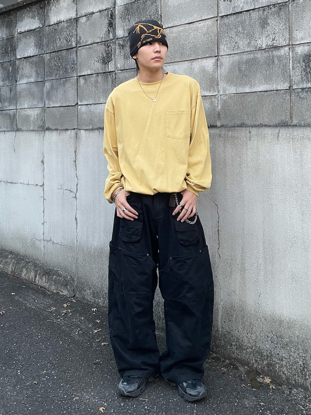 イエロー系のTシャツ/カットソー、ブラック系のカーゴパンツ、ブラック系のスニーカーを着用したメンズの秋コーディネートの2枚目の写真