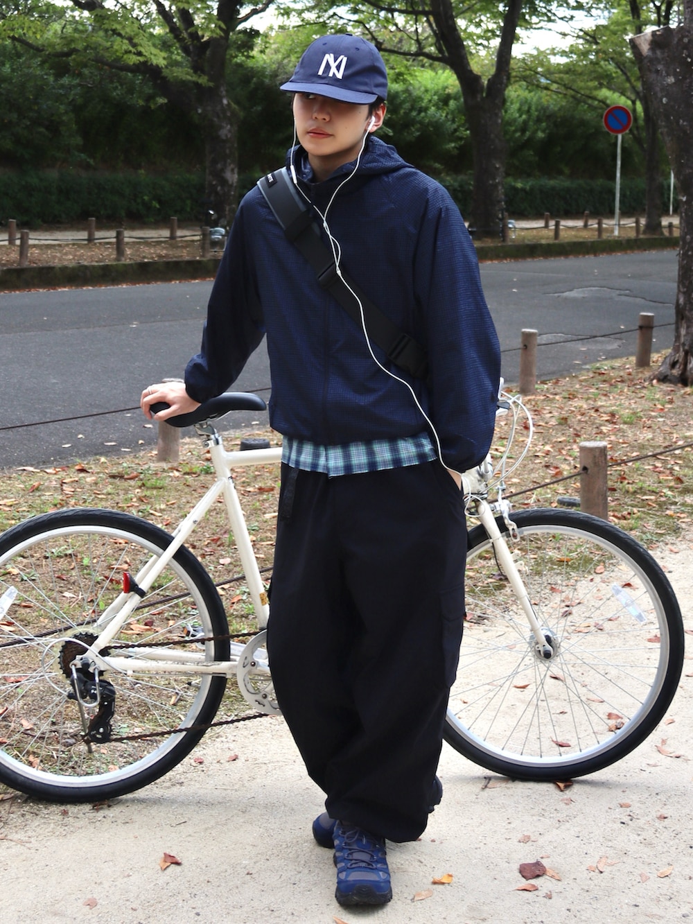 グレー系のスニーカー、ブラック系のカーゴパンツ、グレー系のショルダーバッグを着用したメンズの秋コーディネートの2枚目の写真