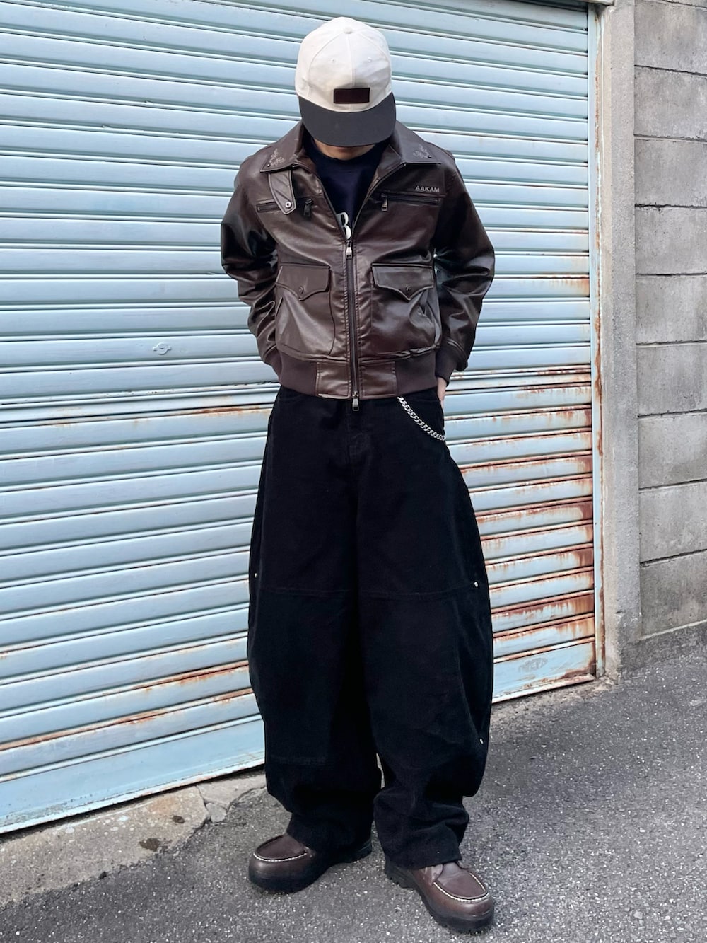 ブラウン系のブーツ、ブルー系のスウェット、その他のライダースジャケットを着用したメンズの冬コーディネートの2枚目の写真