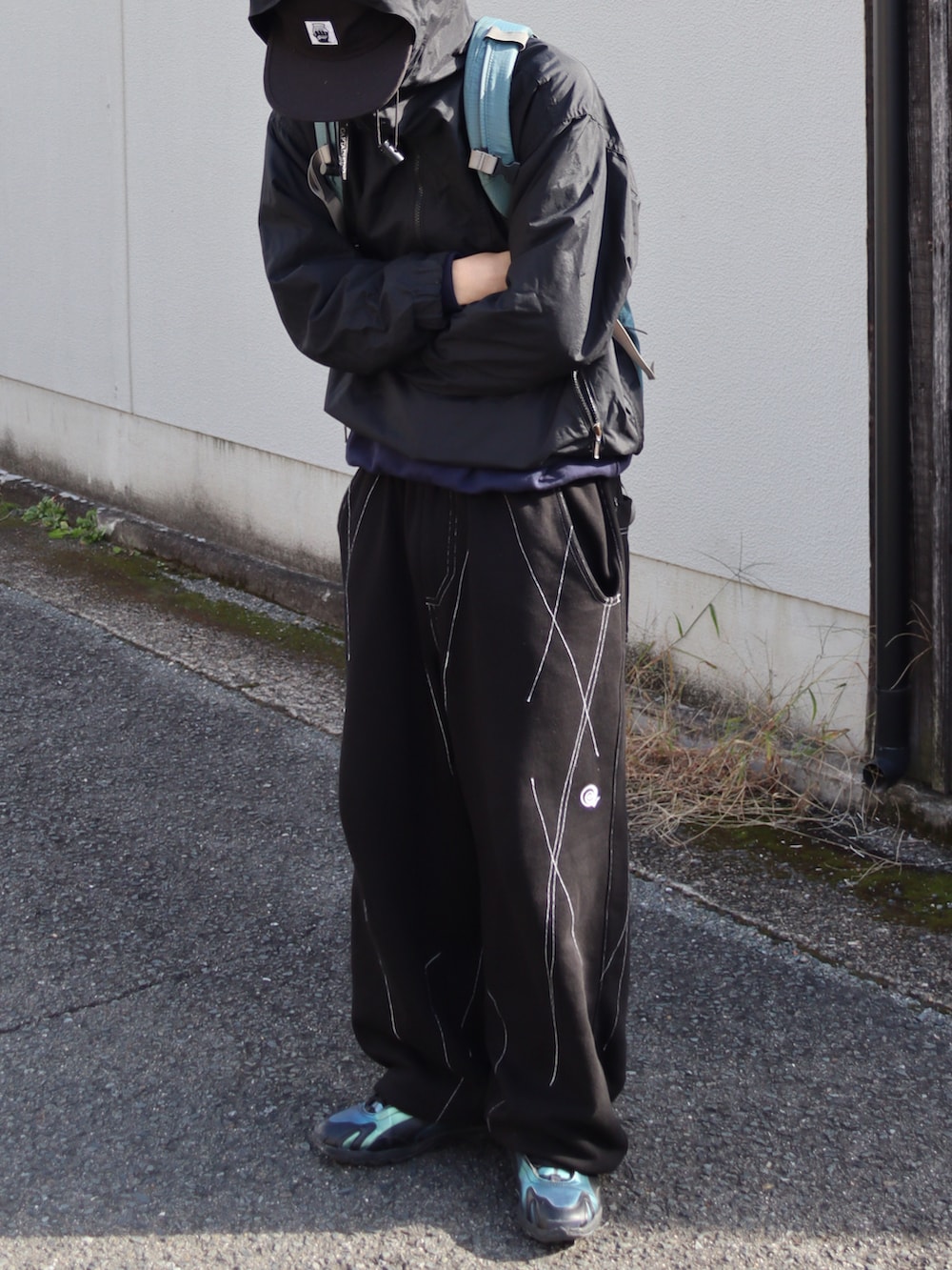 ブラック系のスニーカー、ブルー系のスウェット、ブラック系のマウンテンパーカーを着用したメンズの秋コーディネートの3枚目の写真