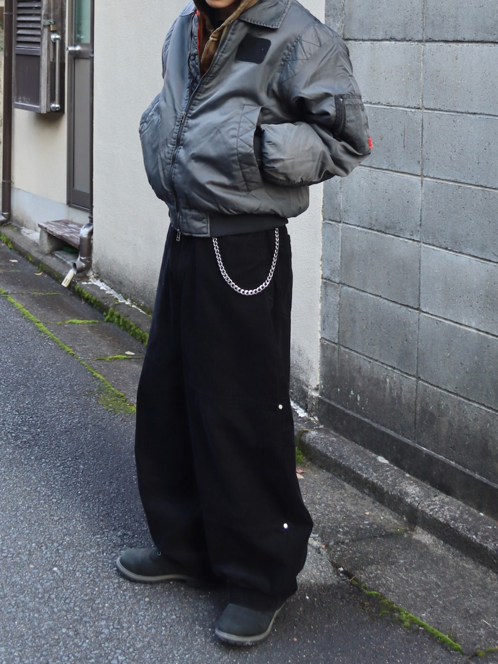 グリーン系のパーカー、ブラック系のブーツ、その他のMA-1を着用したメンズの冬コーディネートの5枚目の写真