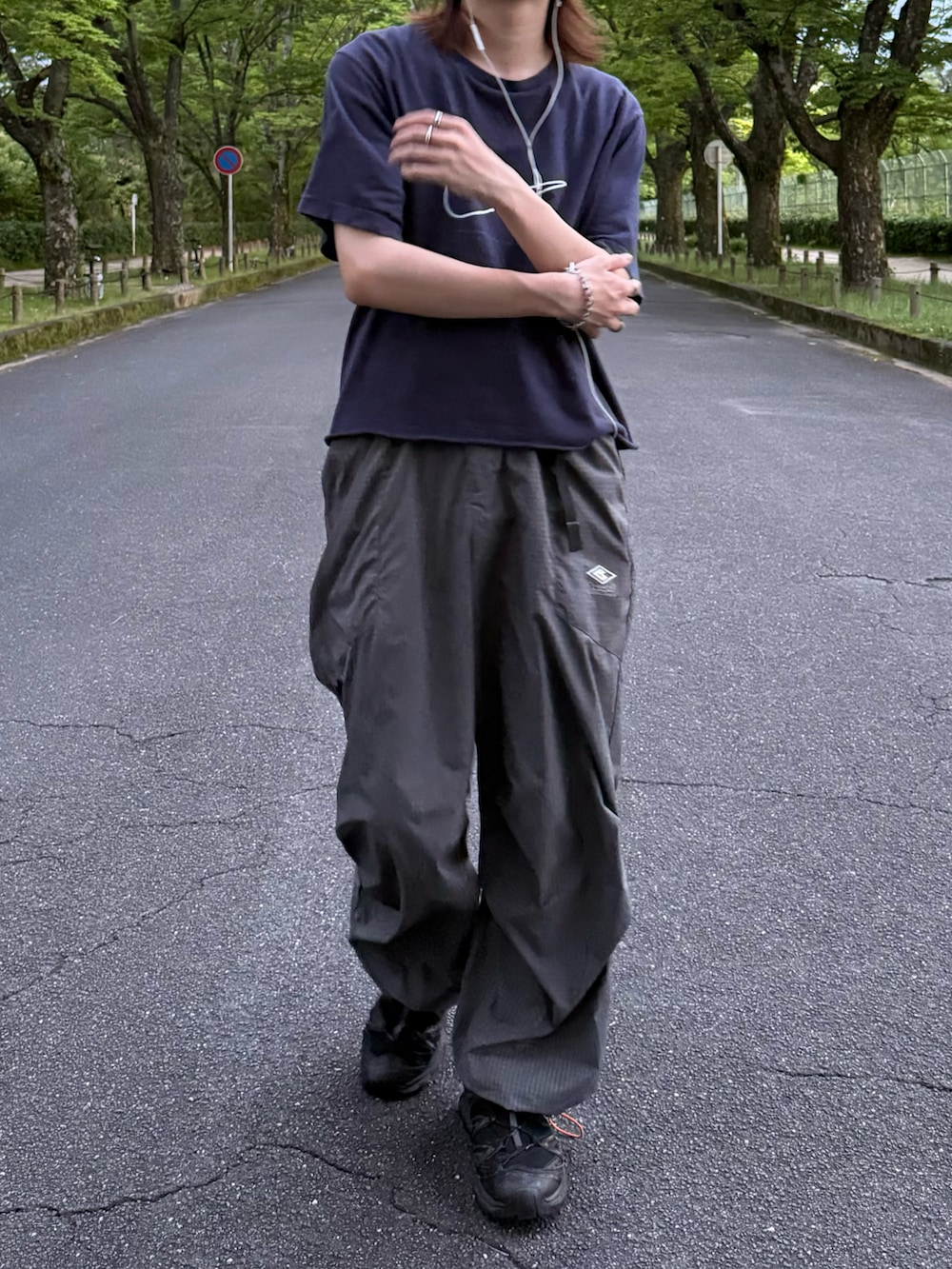 グレー系のカーゴパンツ、ブラック系のスニーカー、ブルー系のTシャツ/カットソーを着用したメンズの夏コーディネートの3枚目の写真