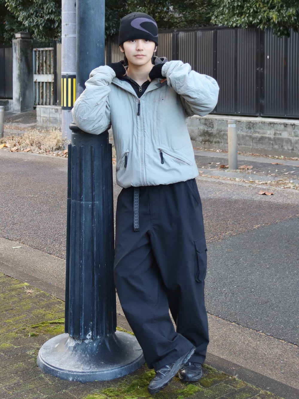 ブラック系のスニーカー、ブラック系のカーゴパンツ、ブラック系のパーカーを着用したメンズの冬コーディネートの2枚目の写真