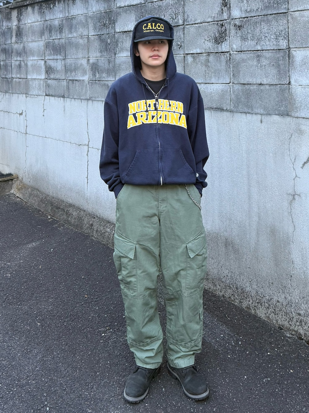 ブルー系のパーカー、グリーン系のカーゴパンツ、ブラック系のブーツを着用したメンズの秋コーディネートの2枚目の写真