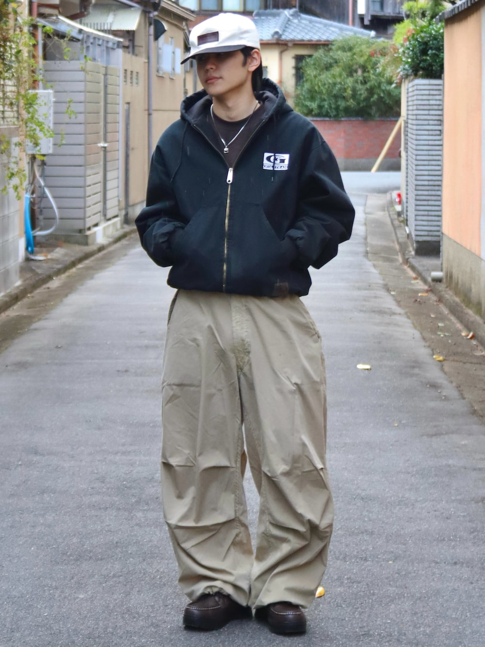 ブラウン系のTシャツ/カットソー、ベージュ系のカーゴパンツ、ブラウン系のブーツを着用したメンズの秋コーディネートの2枚目の写真