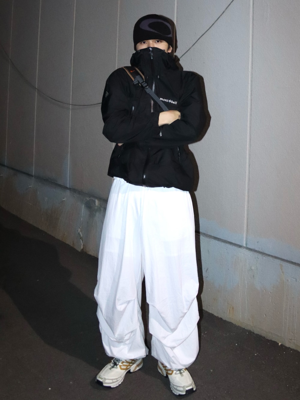 ホワイト系のスニーカー、ホワイト系のその他パンツ、ブラック系のマウンテンパーカーを着用したメンズの秋コーディネートの2枚目の写真