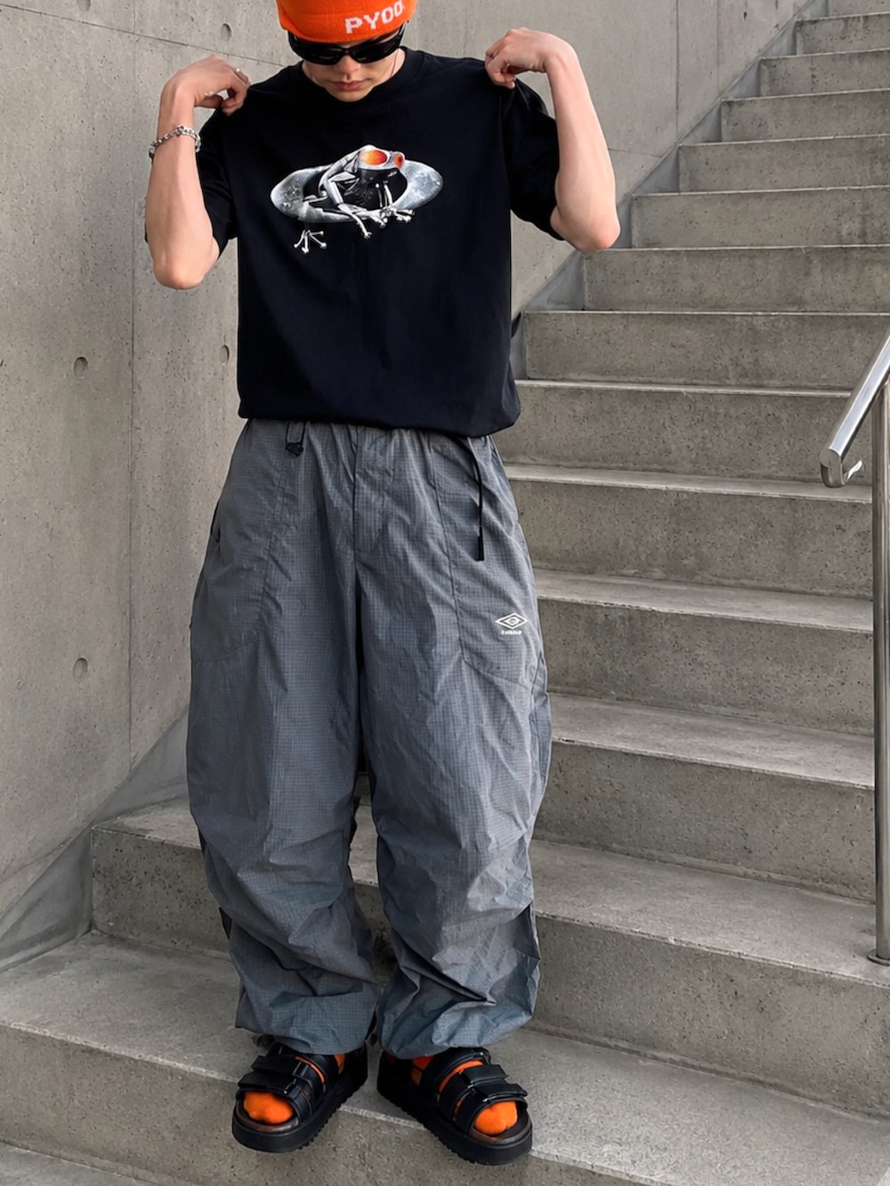 ブラック系のTシャツ/カットソー、ブラック系のサンダル、グレー系のカーゴパンツを着用したメンズの夏コーディネートの3枚目の写真