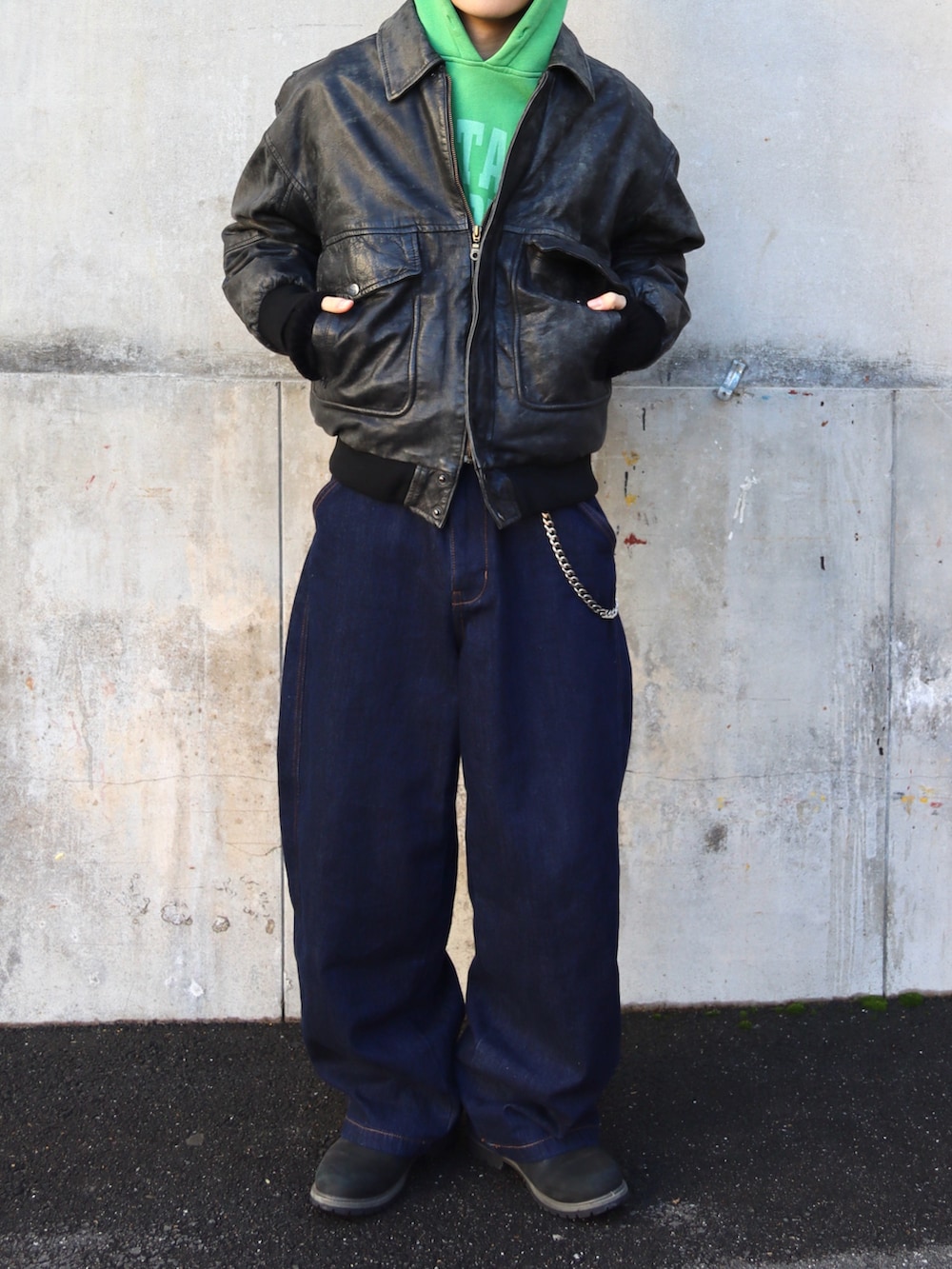 ブラック系のブーツ、その他のデニムパンツ、グリーン系のパーカーを着用したメンズの冬コーディネートの5枚目の写真