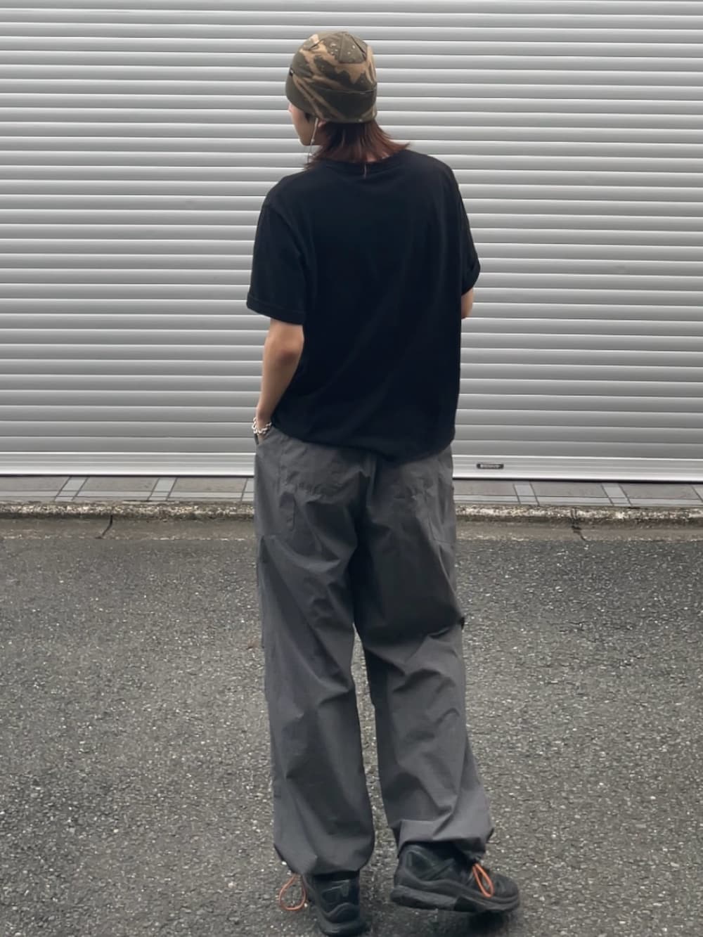 ブラック系のTシャツ/カットソー、グレー系のカーゴパンツ、ブラック系のスニーカーを着用したメンズの夏コーディネートの3枚目の写真
