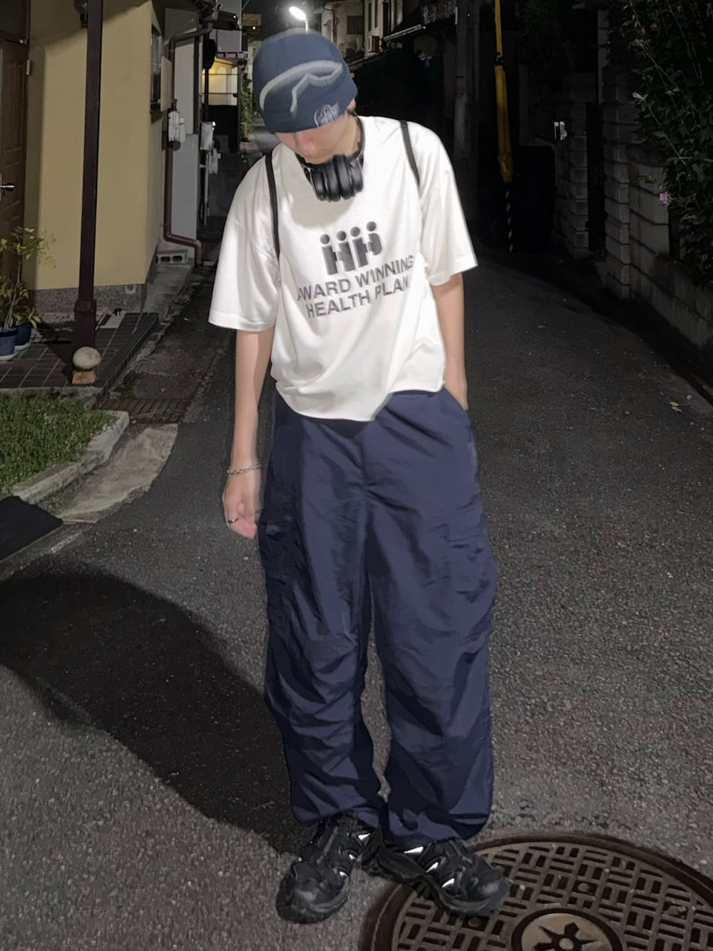 ブルー系のカーゴパンツ、ホワイト系のTシャツ/カットソー、ブラック系のスニーカーを着用したメンズの夏コーディネートの3枚目の写真