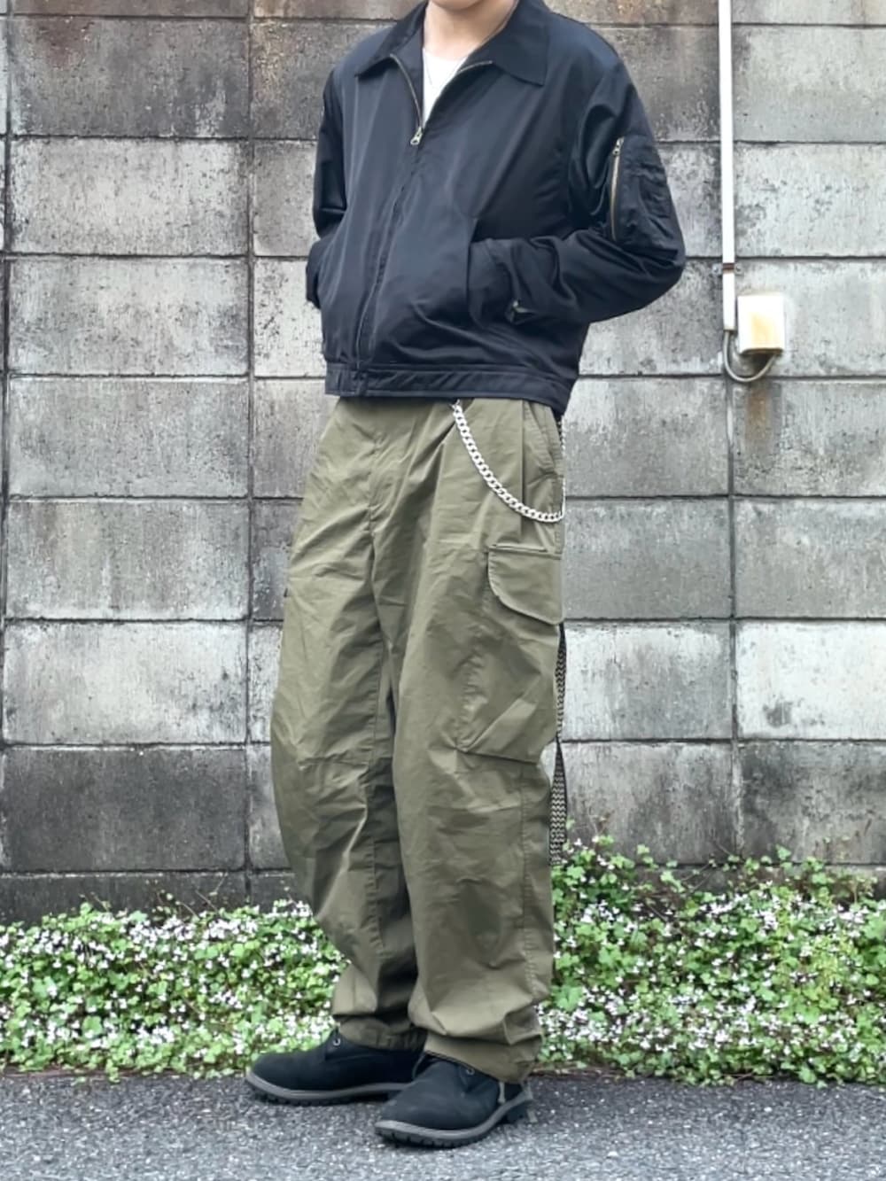 ブラック系のブーツ、ホワイト系のTシャツ/カットソー、ブラック系のミリタリージャケットを着用したメンズの春コーディネートの3枚目の写真