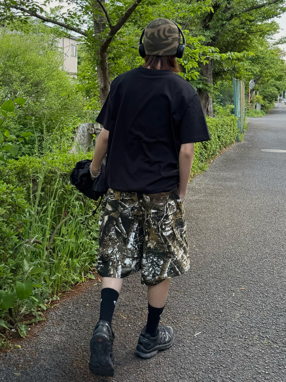 ブラック系のスニーカー、グリーン系のニットキャップ/ビーニー、ブラック系のソックス/靴下を着用したメンズの春コーディネートの3枚目の写真