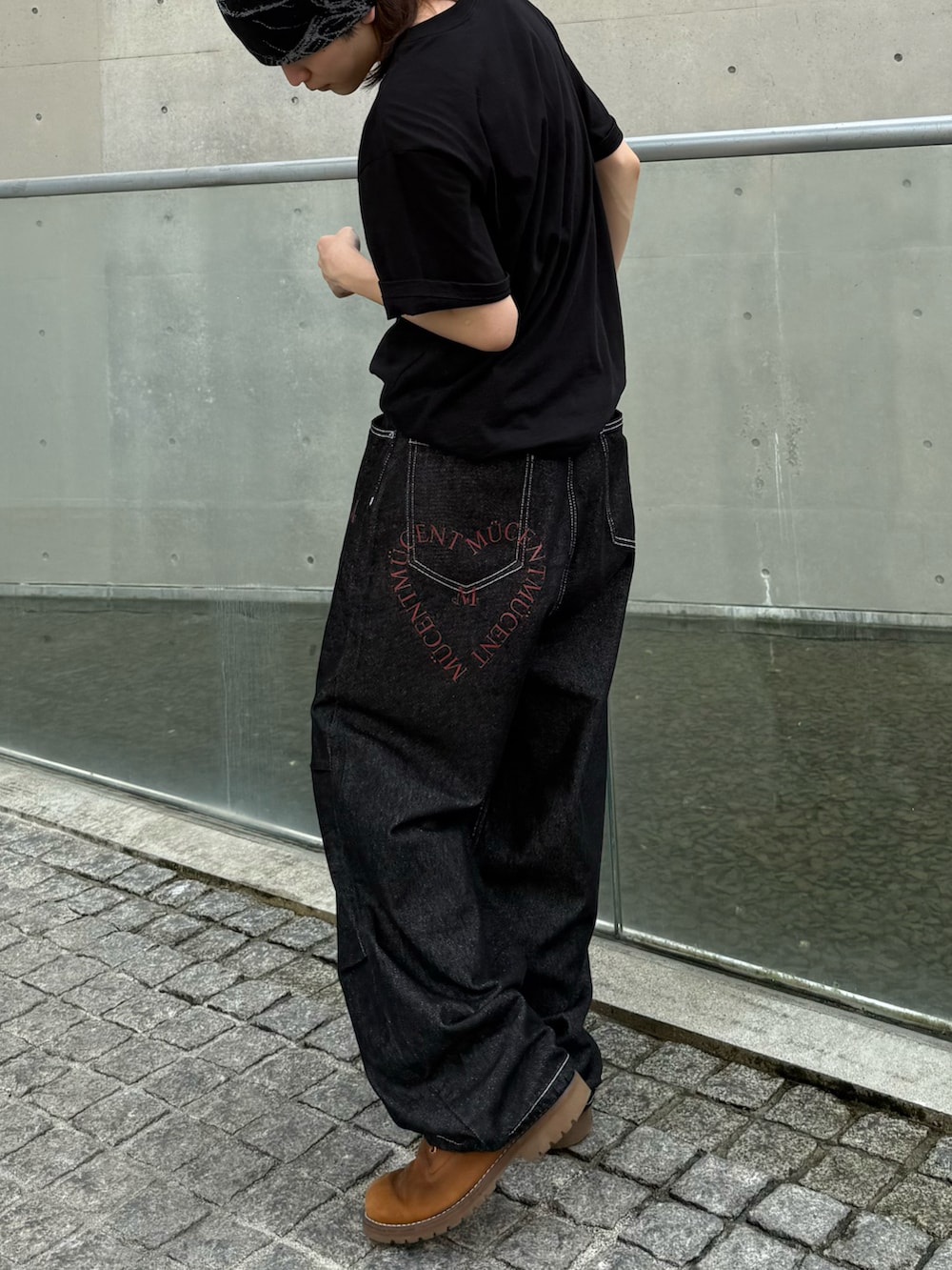 ブラウン系のブーツ、ブラック系のTシャツ/カットソー、ブラック系のデニムパンツを着用したメンズの夏コーディネートの5枚目の写真