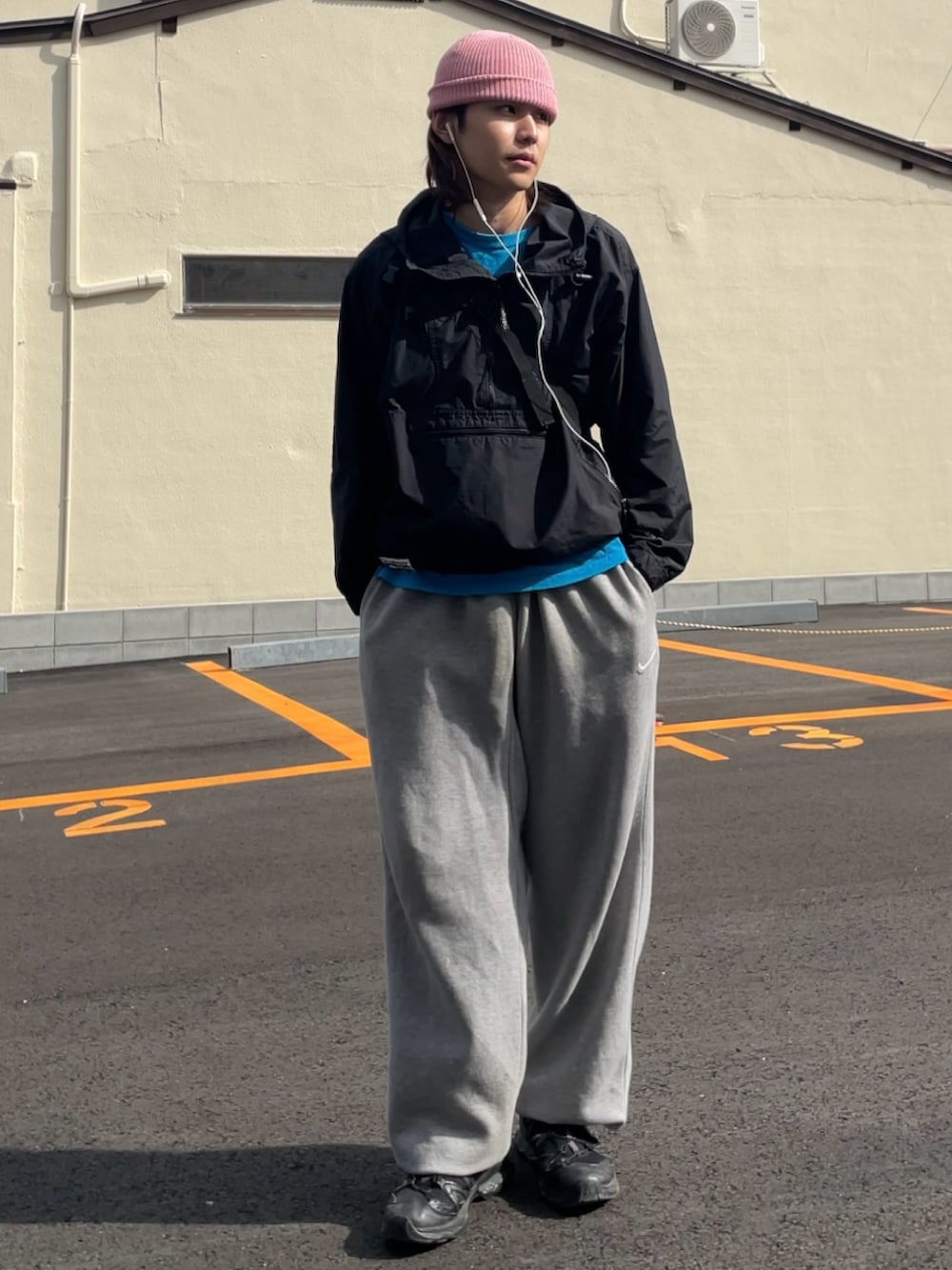 ブラック系のマウンテンパーカー、グレー系のスウェットパンツ、ブラック系のスニーカーを着用したメンズの春コーディネートの2枚目の写真