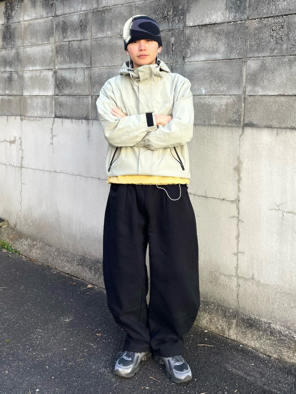 グリーン系のマウンテンパーカー、ブラック系のスウェットパンツ、イエロー系のTシャツ/カットソーを着用したメンズの春コーディネートの2枚目の写真