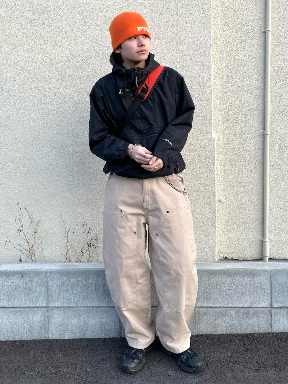 ベージュ系のその他パンツ、オレンジ系のショルダーバッグ、ブラック系のスニーカーを着用したメンズの春コーディネートの2枚目の写真