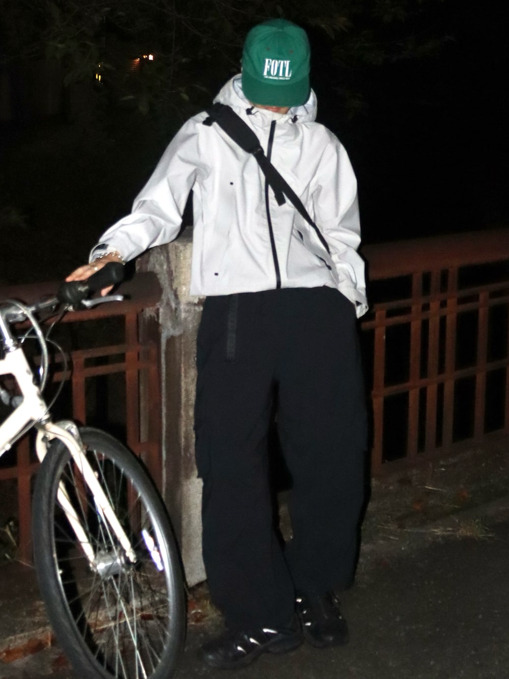 ブラック系のカーゴパンツ、ブラック系のスニーカー、ブラック系のショルダーバッグを着用したメンズの秋コーディネートの2枚目の写真