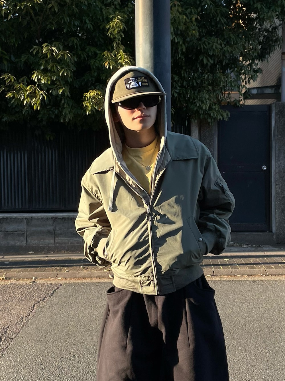 ブラック系のスウェットパンツ、イエロー系のTシャツ/カットソー、グリーン系のブルゾンを着用したメンズの春コーディネートの3枚目の写真