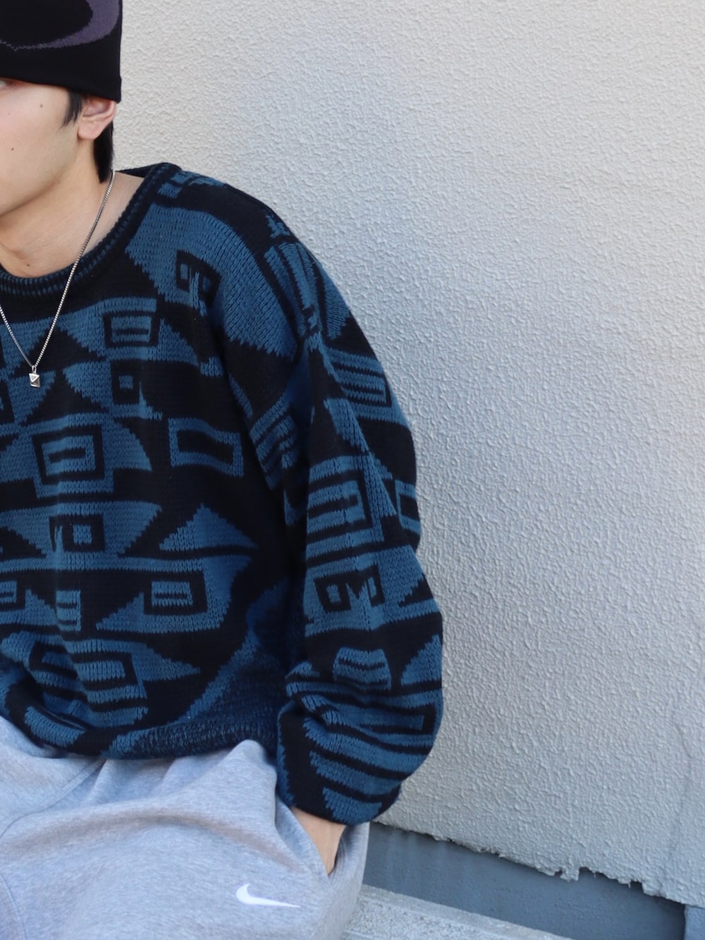 ブラック系のローファー、ブルー系のニット/セーター、グレー系のスウェットパンツを着用したメンズの秋コーディネートの4枚目の写真