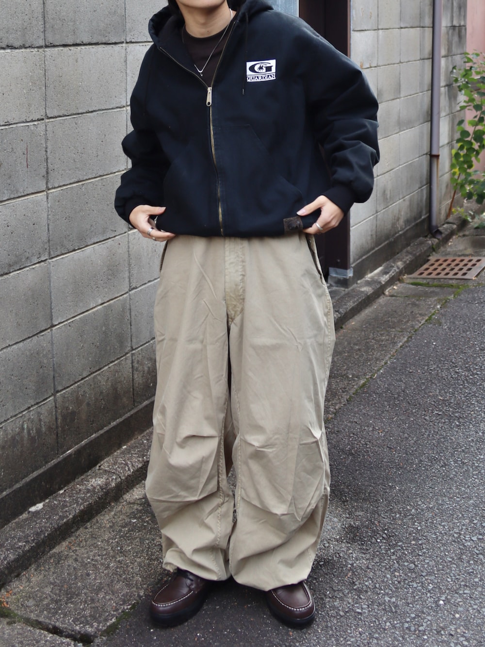 ブラウン系のTシャツ/カットソー、ベージュ系のカーゴパンツ、ブラウン系のブーツを着用したメンズの秋コーディネートの4枚目の写真