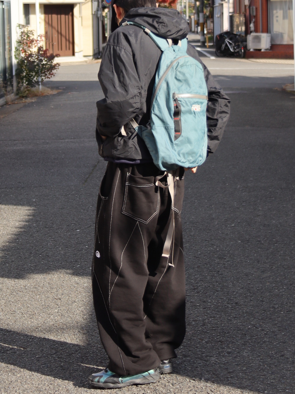 ブラック系のスニーカー、ブルー系のスウェット、ブラック系のマウンテンパーカーを着用したメンズの秋コーディネートの4枚目の写真