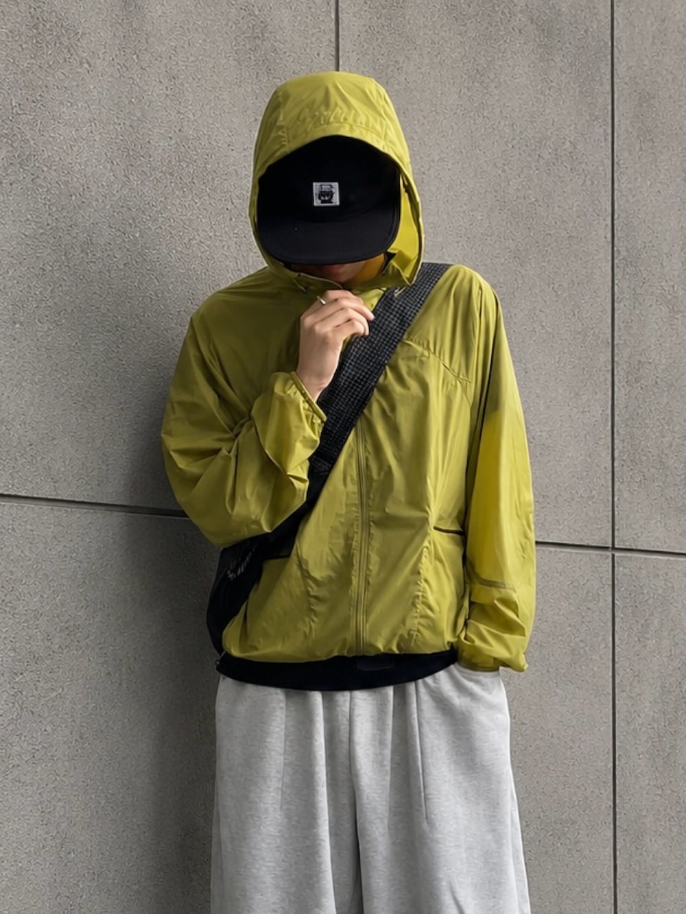 ブラック系のTシャツ/カットソー、グリーン系のマウンテンパーカー、ブルー系のスニーカーを着用したメンズの夏コーディネートの4枚目の写真