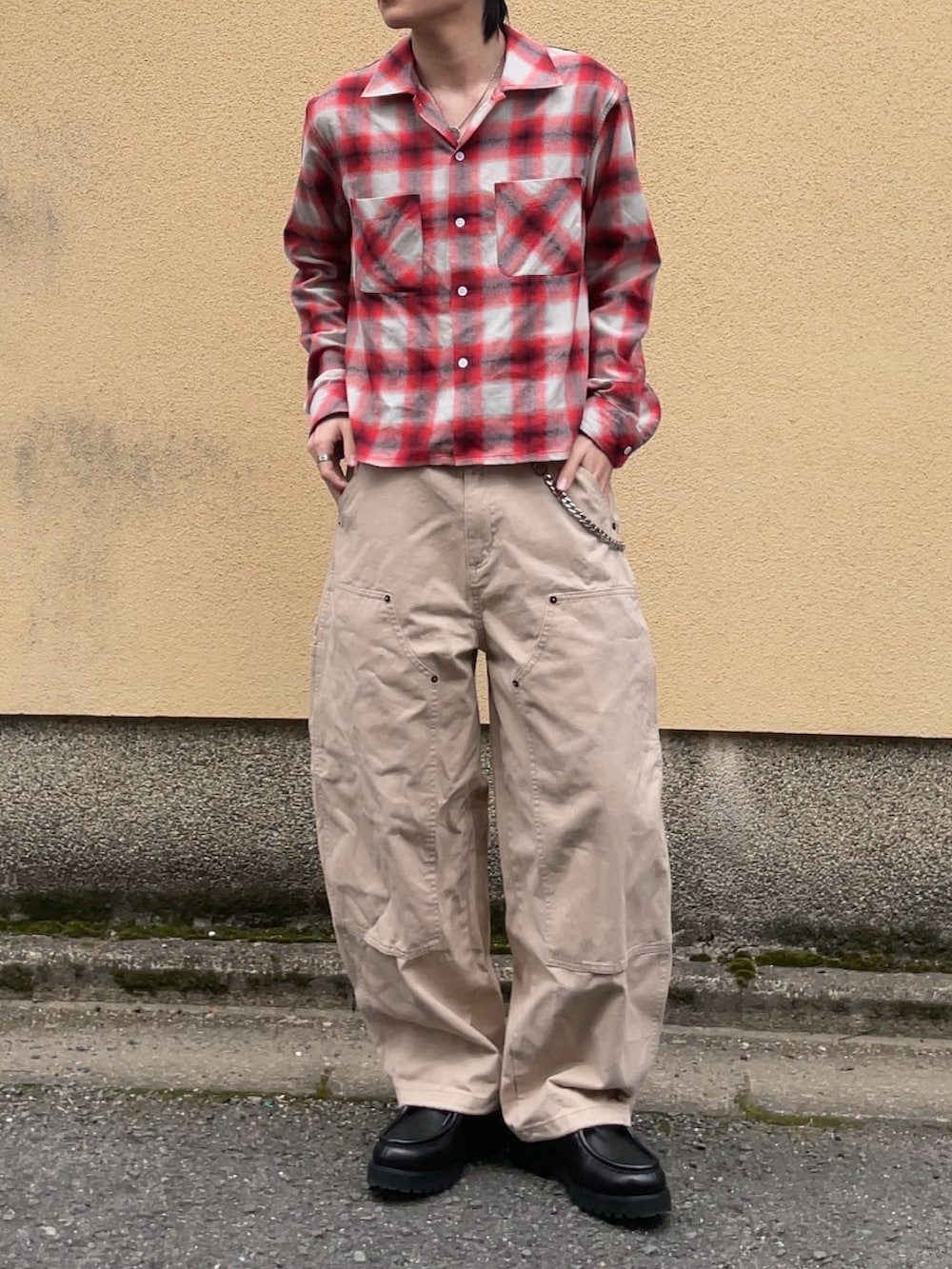 ベージュ系のその他パンツ、ブラック系のドレスシューズ、レッド系のシャツ/ブラウスを着用したメンズの春コーディネートの3枚目の写真
