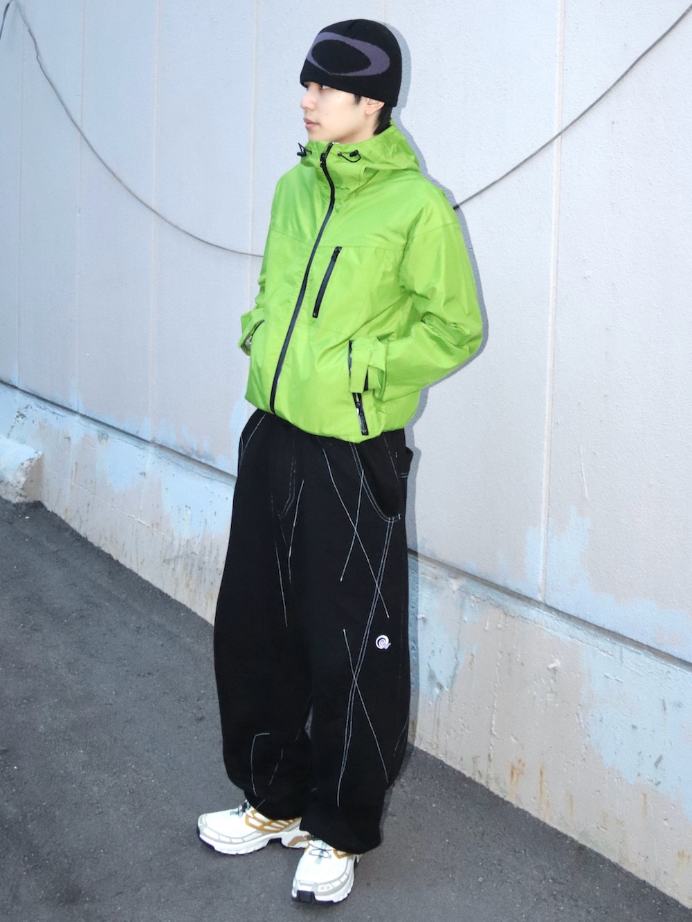 ホワイト系のスニーカー、グリーン系のマウンテンパーカー、ブラック系のスウェットパンツを着用したメンズの秋コーディネートの2枚目の写真