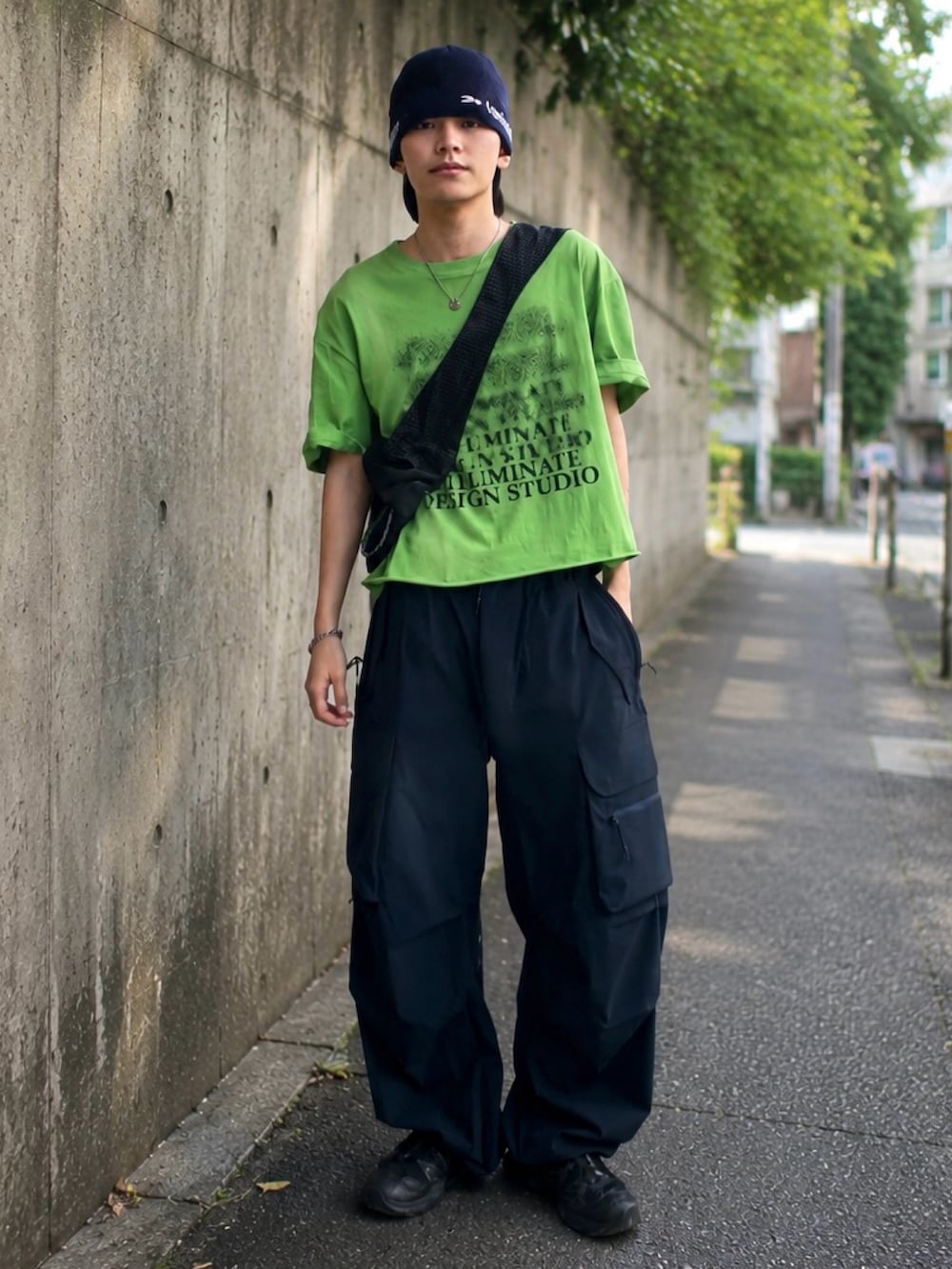ブルー系のカーゴパンツ、ブラック系のショルダーバッグ、ブラック系のスニーカーを着用したメンズの夏コーディネートの2枚目の写真
