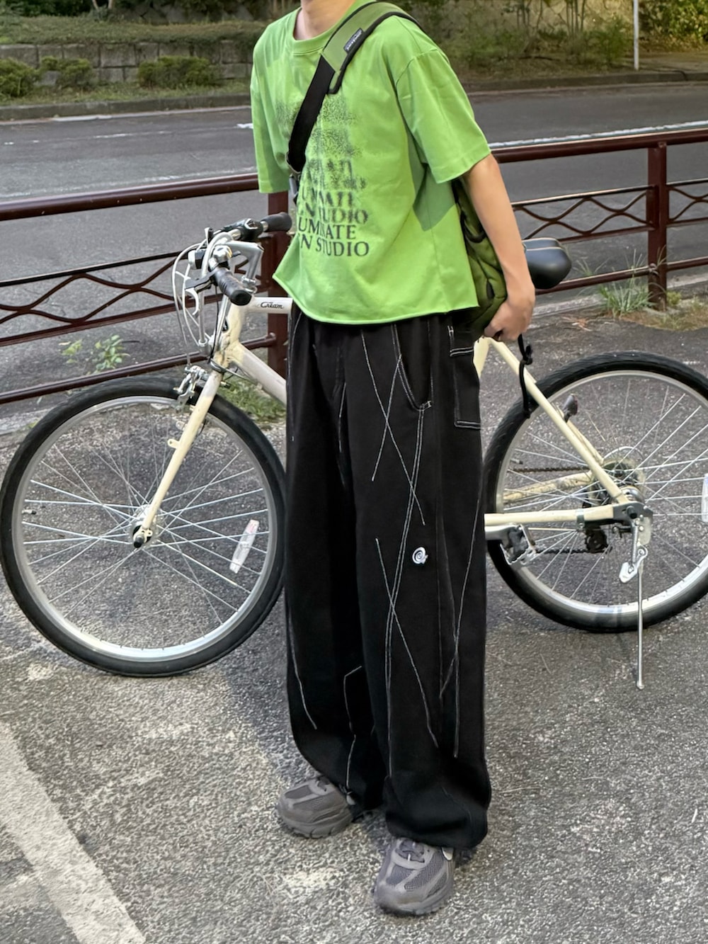 グレー系のスニーカー、グリーン系のメッセンジャーバッグを着用したメンズの夏コーディネートの3枚目の写真