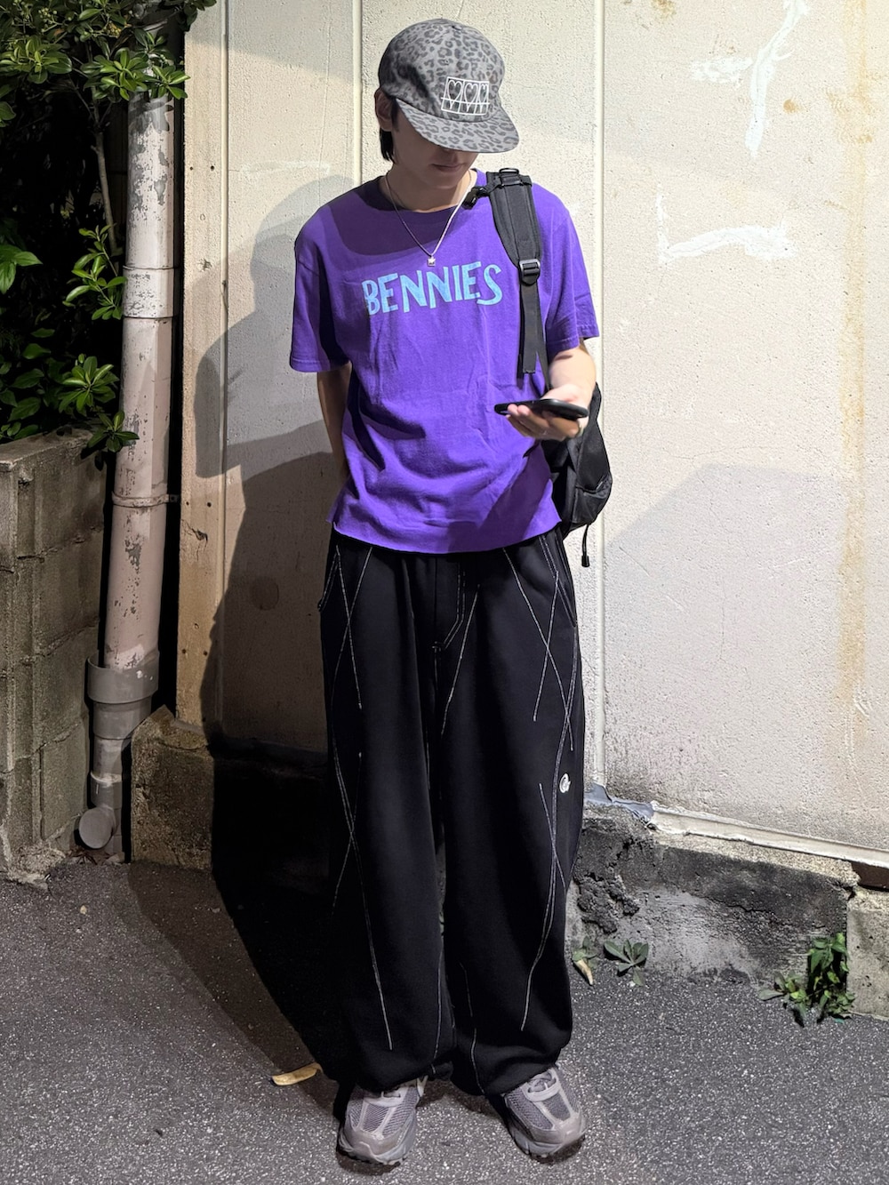 グレー系のスニーカー、パープル系のTシャツ/カットソー、ブラック系のスウェットパンツを着用したメンズの秋コーディネートの2枚目の写真