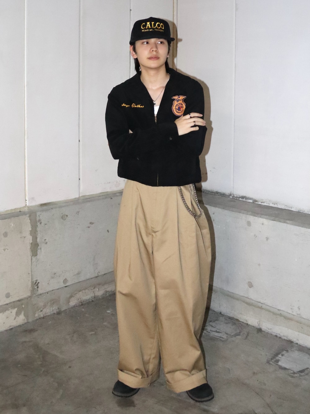 ブラック系のミリタリージャケット、ベージュ系のチノパンツ、ブラック系のブーツを着用したメンズの秋コーディネートの2枚目の写真