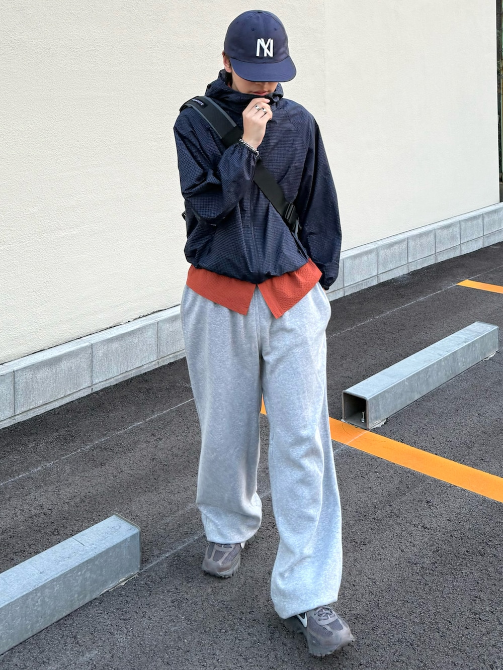 オレンジ系のシャツ/ブラウス、グレー系のスニーカー、ブルー系のマウンテンパーカーを着用したメンズの夏コーディネートの3枚目の写真