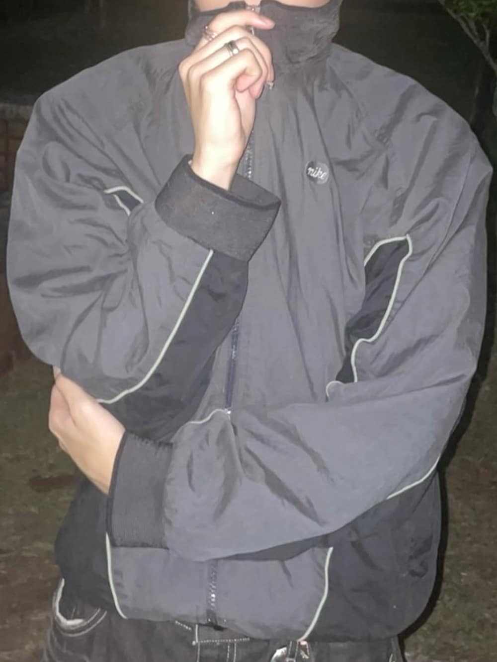 ブラック系のナイロンジャケットを着用したメンズの春コーディネートの2枚目の写真