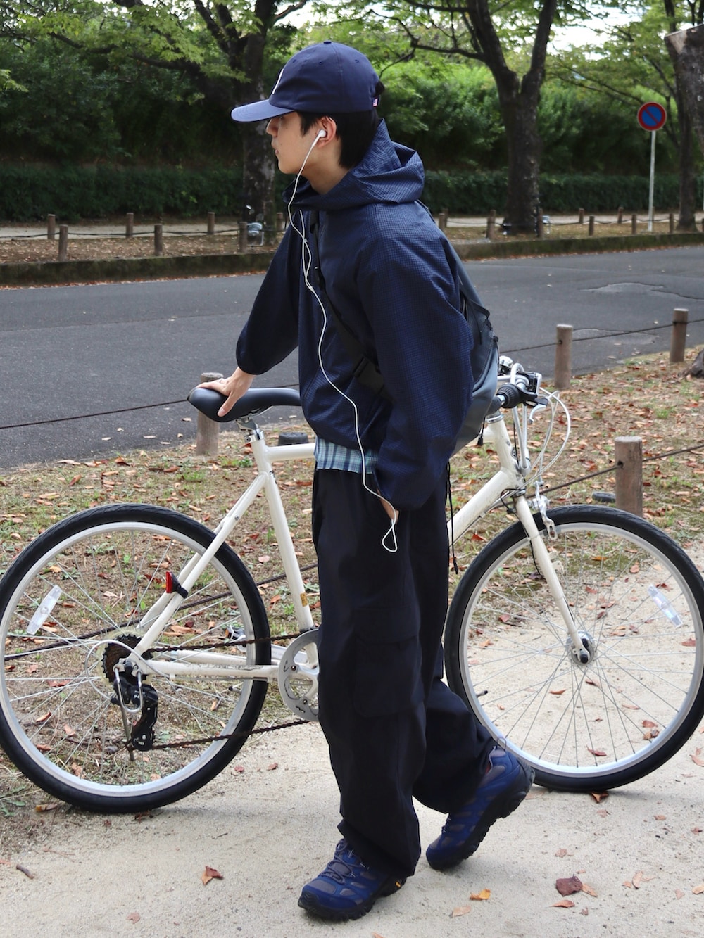 グレー系のスニーカー、ブラック系のカーゴパンツ、グレー系のショルダーバッグを着用したメンズの秋コーディネートの3枚目の写真