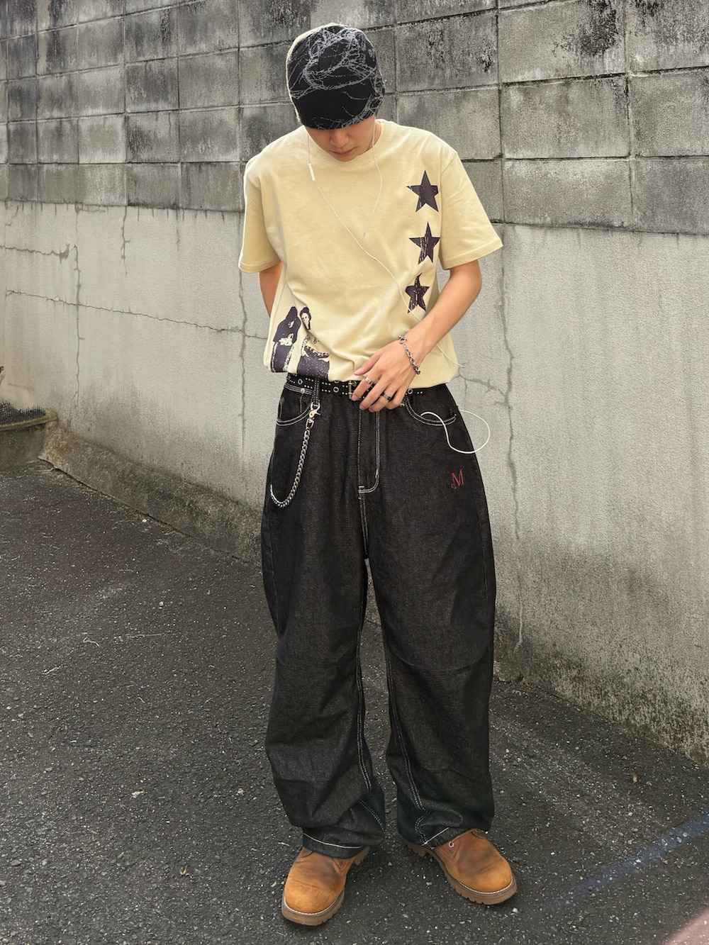 ベージュ系のTシャツ/カットソー、ブラック系のデニムパンツ、オレンジ系のブーツを着用したメンズの夏コーディネートの2枚目の写真