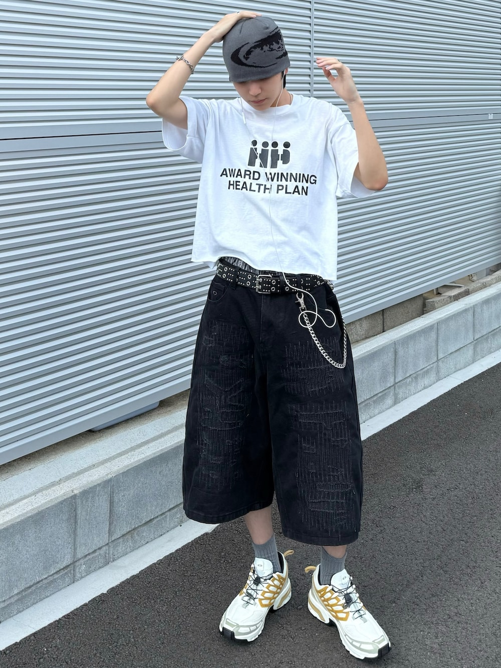 ホワイト系のスニーカー、ホワイト系のTシャツ/カットソー、ブラック系のデニムパンツを着用したメンズの夏コーディネートの2枚目の写真