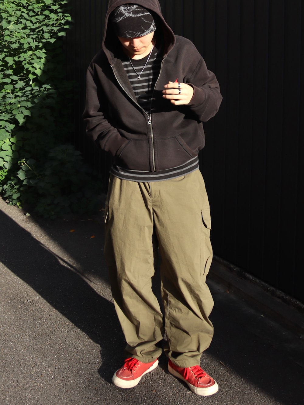 グリーン系のカーゴパンツ、その他のTシャツ/カットソー、ブラック系のパーカーを着用したメンズの冬コーディネートの2枚目の写真