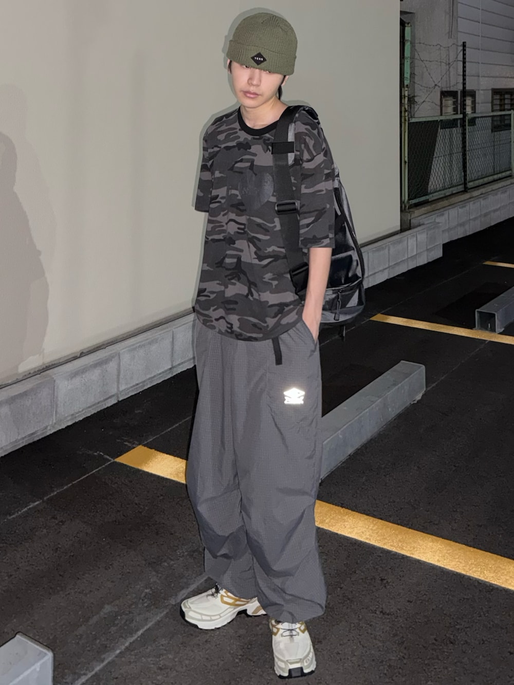 グレー系のTシャツ/カットソー、グレー系のカーゴパンツ、ホワイト系のスニーカーを着用したメンズの夏コーディネートの3枚目の写真