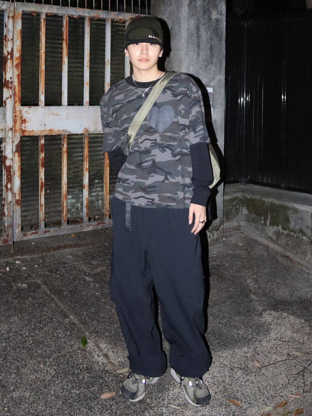 グリーン系のショルダーバッグ、ブラック系のカーゴパンツ、グレー系のTシャツ/カットソーを着用したメンズの秋コーディネートの2枚目の写真