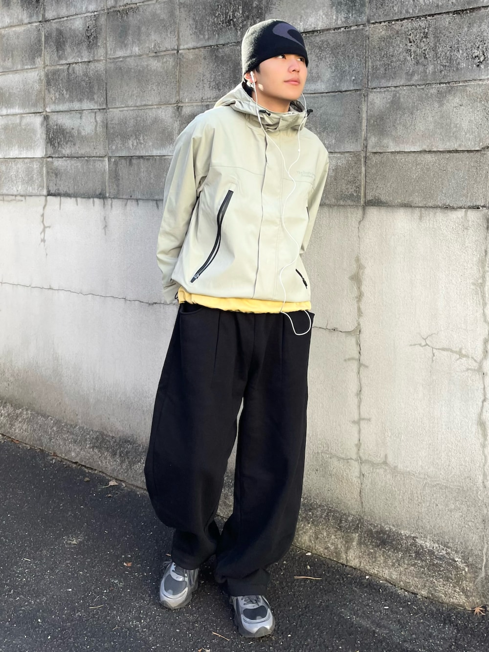 グリーン系のマウンテンパーカー、ブラック系のスウェットパンツ、イエロー系のTシャツ/カットソーを着用したメンズの春コーディネートの3枚目の写真