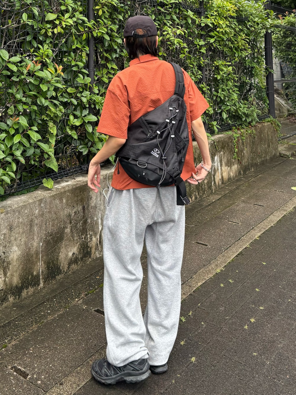 オレンジ系のシャツ/ブラウス、グレー系のスウェットパンツ、ブラック系のスニーカーを着用したメンズの夏コーディネートの3枚目の写真
