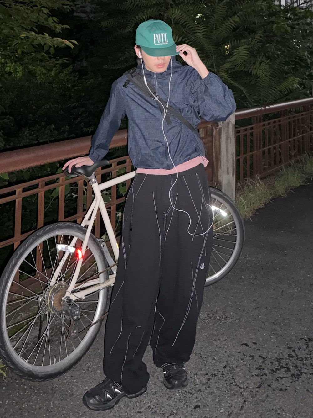 ブラック系のスニーカー、ブルー系のマウンテンパーカー、ブラック系のスウェットパンツを着用したメンズの夏コーディネートの3枚目の写真