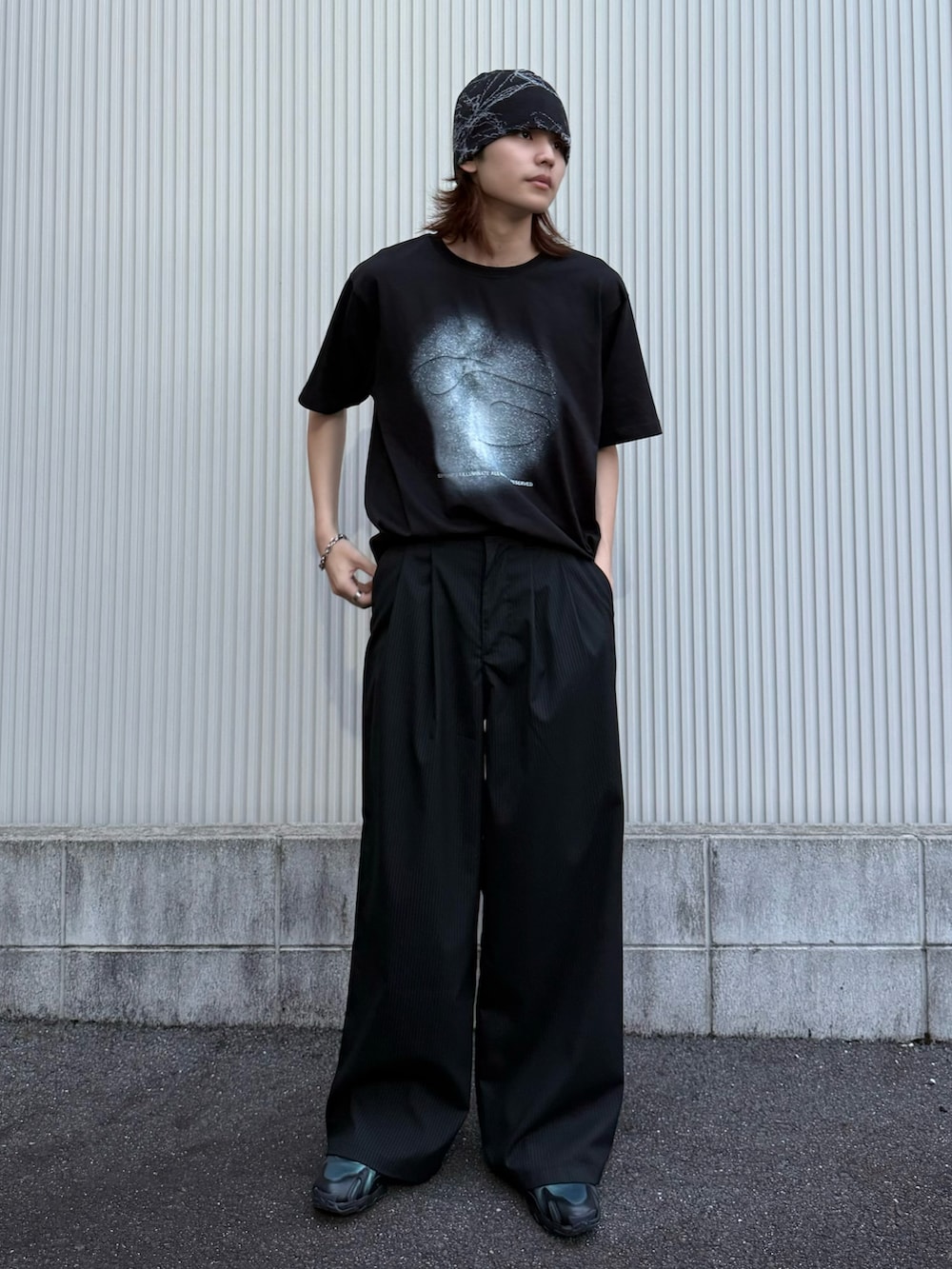 ブラック系のTシャツ/カットソー、ブラック系のスラックス、ブラック系のスニーカーを着用したメンズの夏コーディネートの2枚目の写真