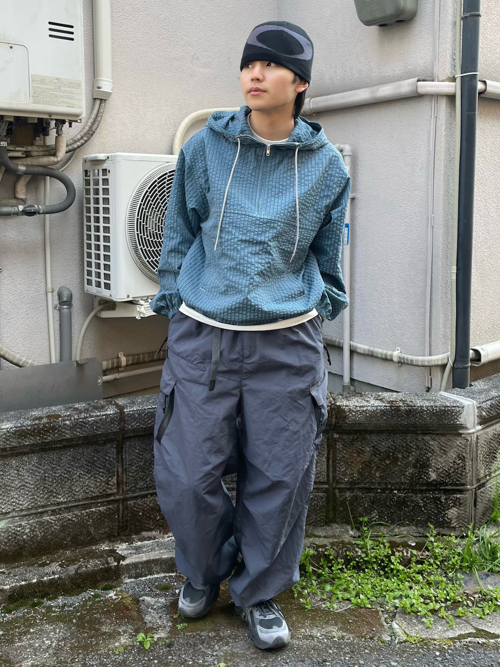 ブルー系のパーカー、グレー系のカーゴパンツ、グレー系のスニーカーを着用したメンズの春コーディネートの3枚目の写真