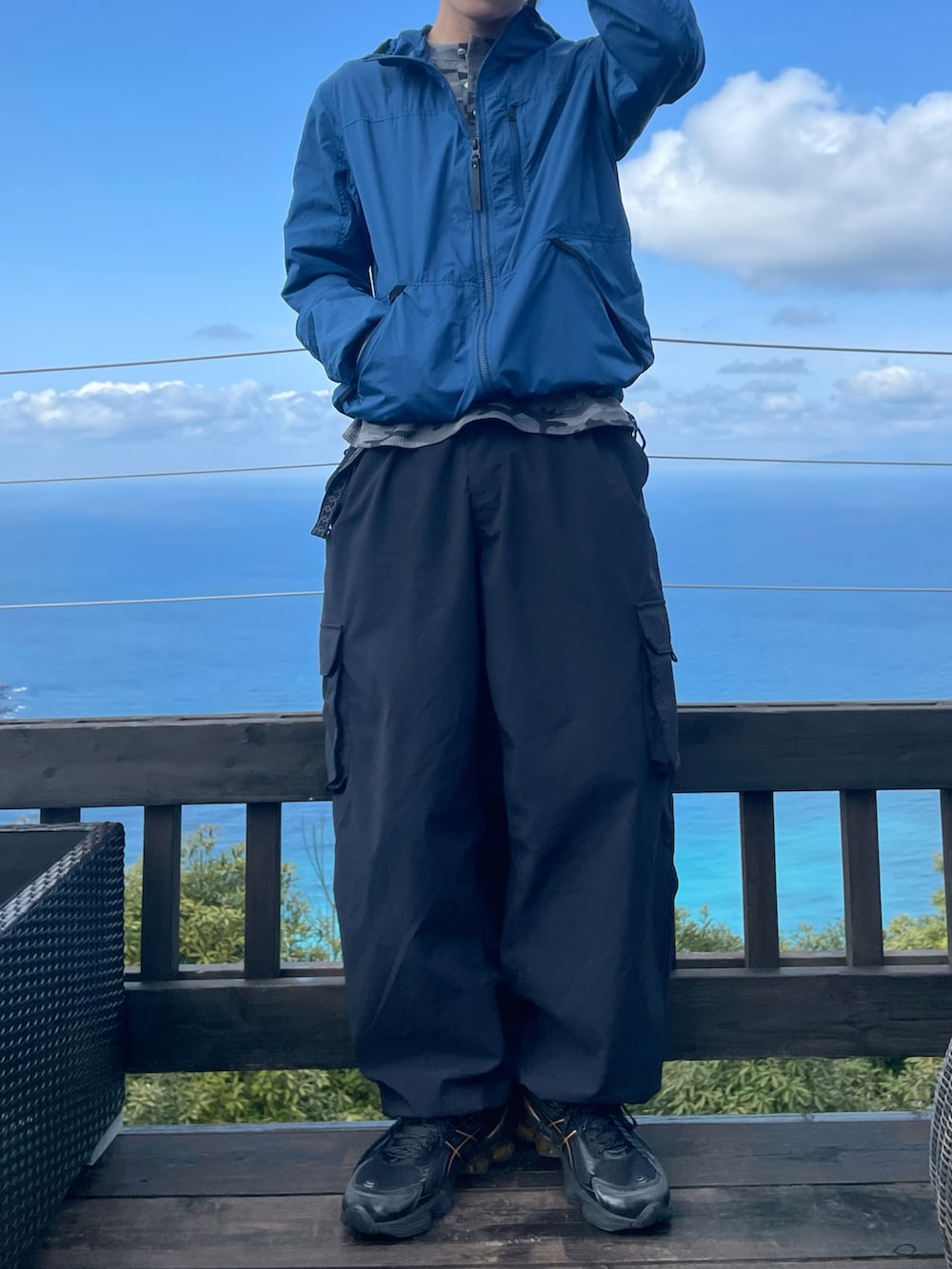 ブルー系のナイロンジャケット、グレー系のTシャツ/カットソー、ブラック系のカーゴパンツを着用したメンズの春コーディネートの3枚目の写真