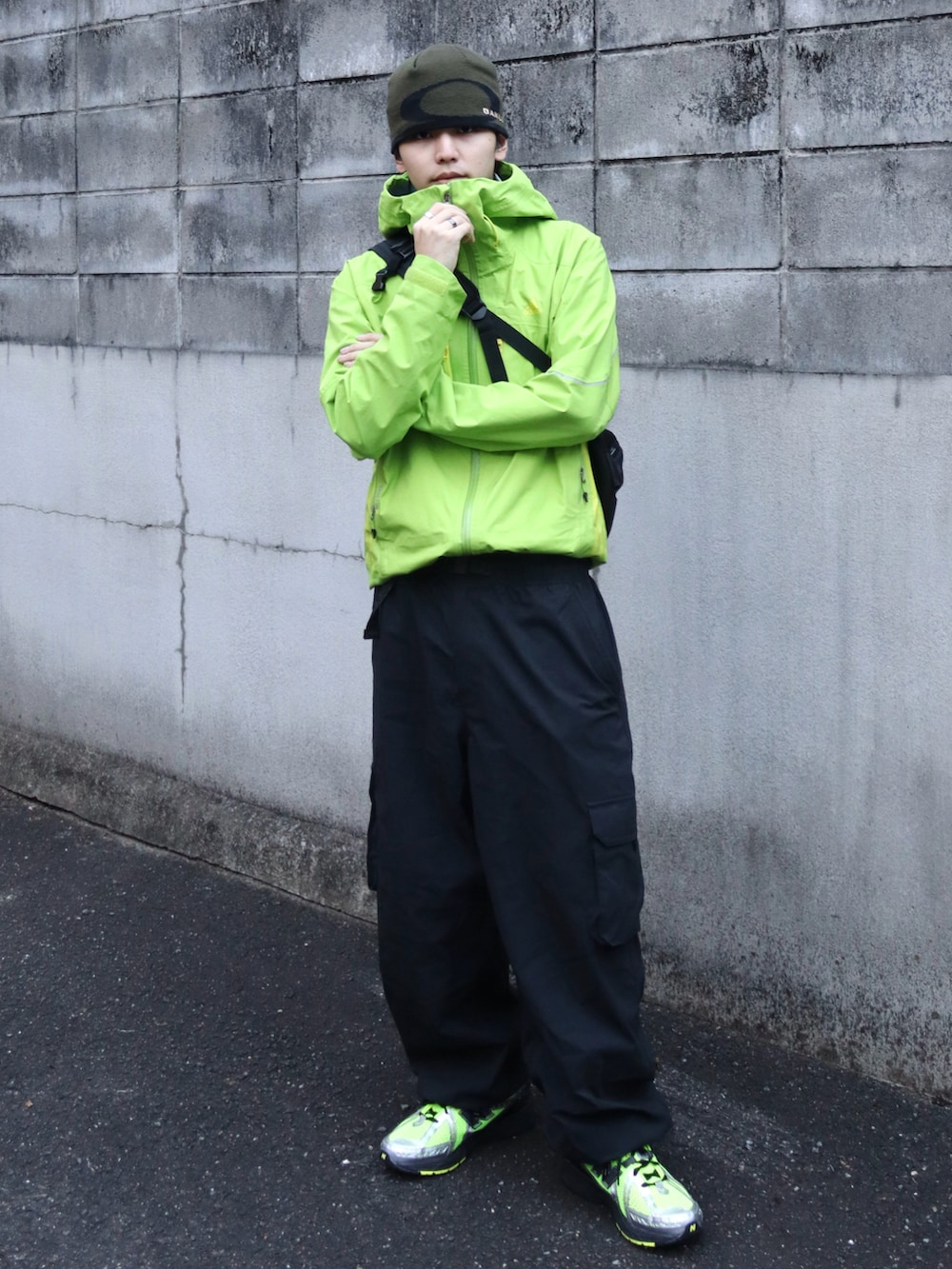 ブラック系のカーゴパンツ、その他のメッセンジャーバッグ、グリーン系のスニーカーを着用したメンズの冬コーディネートの2枚目の写真