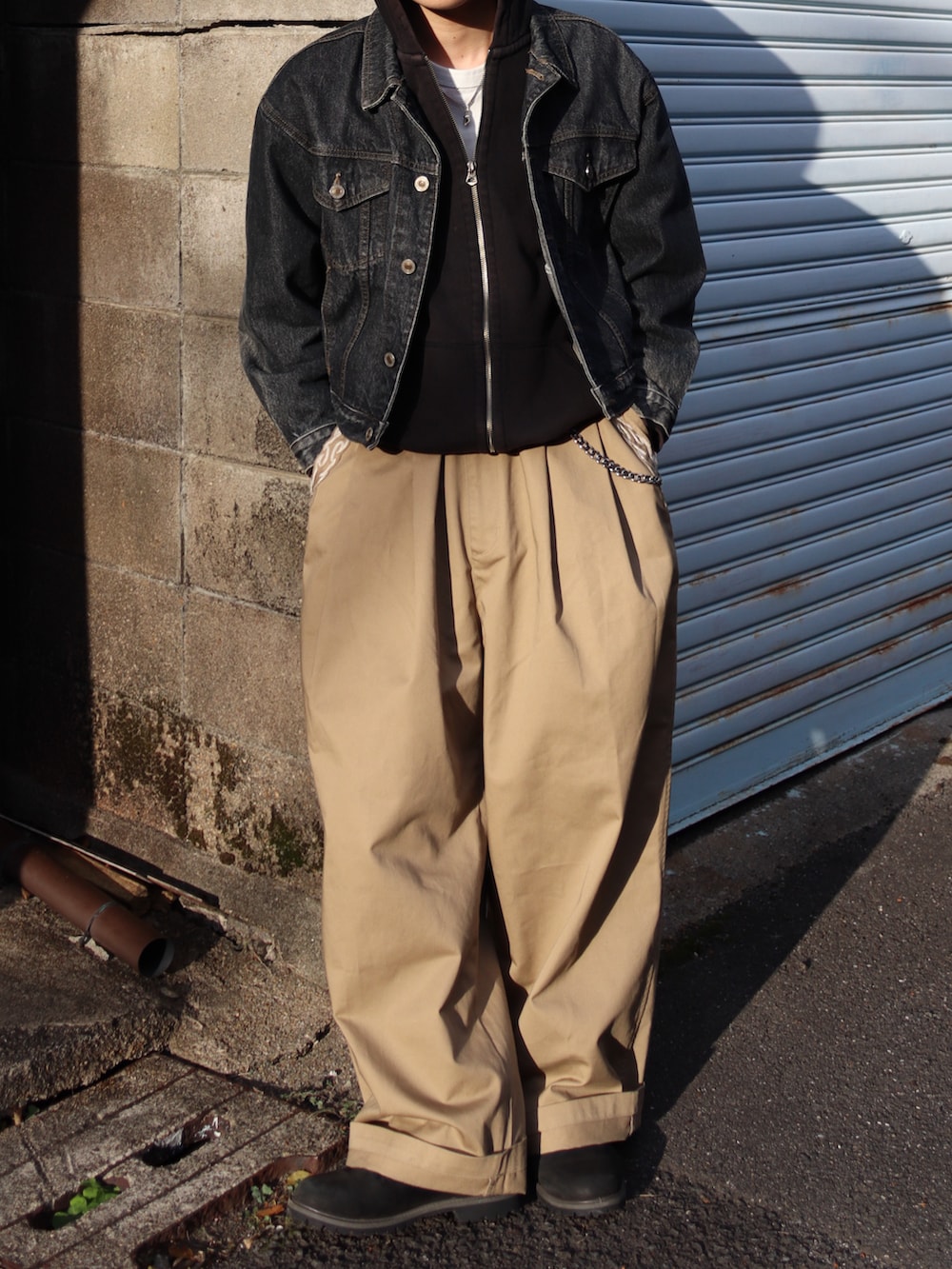 ホワイト系のTシャツ/カットソー、ブラック系のブーツ、ベージュ系のチノパンツを着用したメンズの秋コーディネートの3枚目の写真