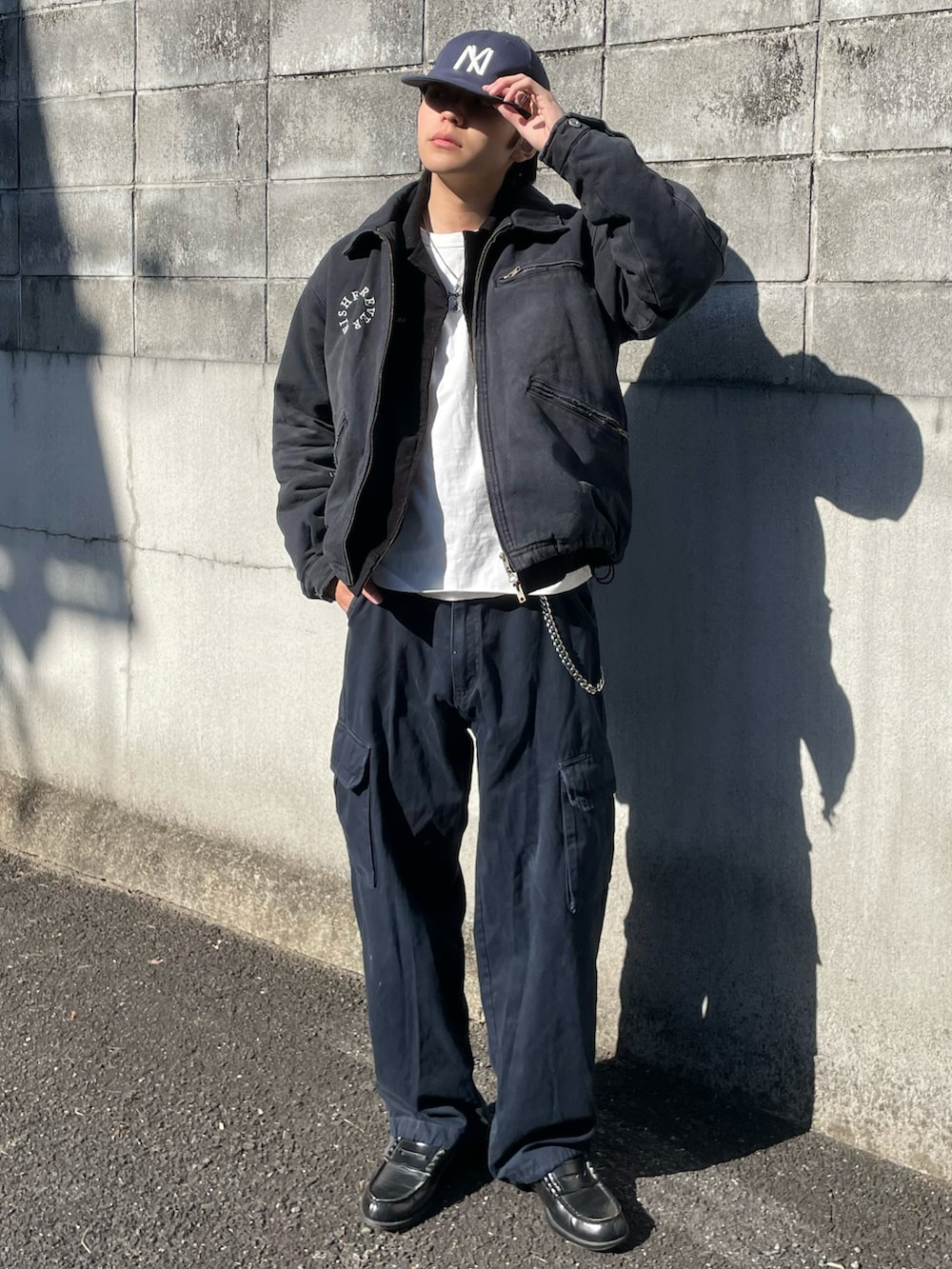 ブラック系のミリタリージャケット、ホワイト系のTシャツ/カットソー、ブラック系のブルゾンを着用したメンズの冬コーディネートの2枚目の写真